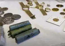 Jewelry, individual and rolled coins displayed on a table