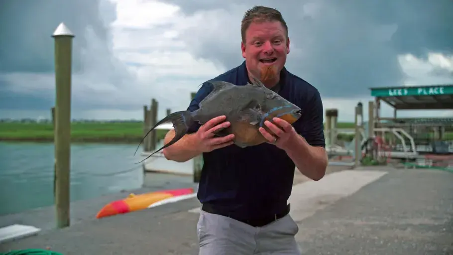 A chef showing off a piece of food at Two Sons Seafood.