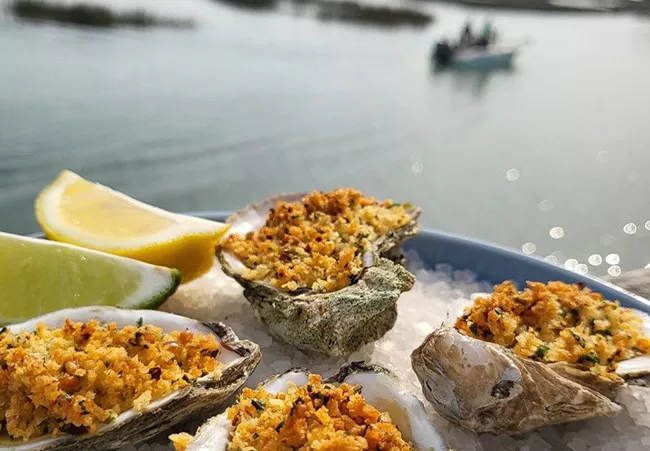 Neptune Bistro oysters with a view of inlet with boat