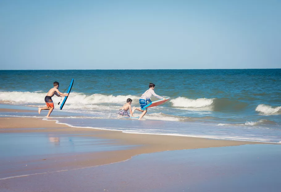 Kids playing in the water with boogie boards at Huntington Beach
