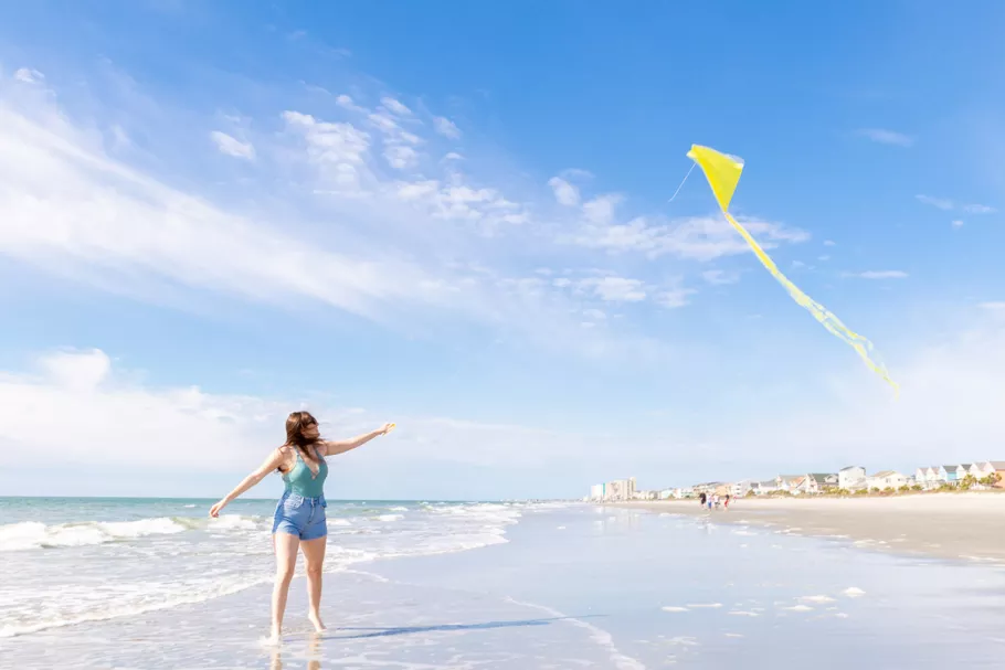 Surfside Beach Oceanfront Hotel - woman on beach flying a kite