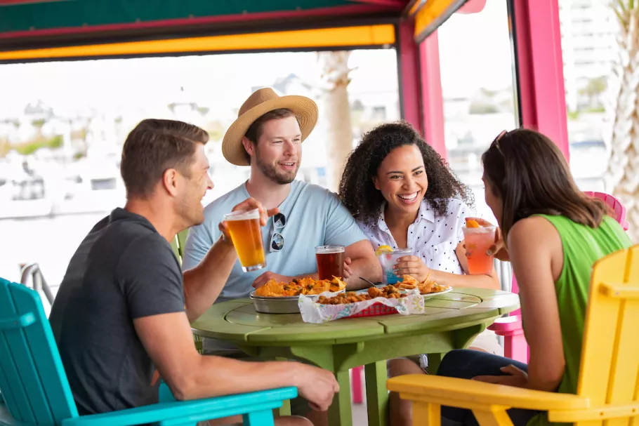 Friends enjoying food and drinks smiling